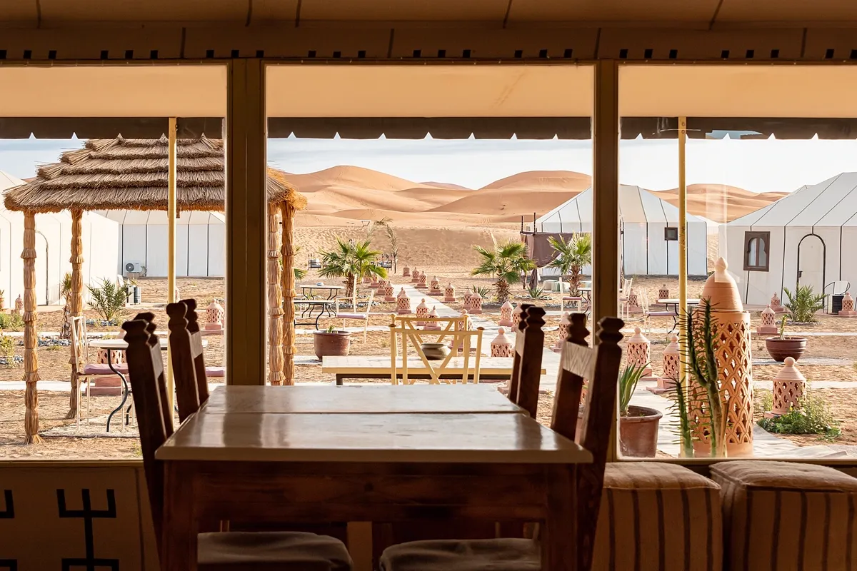 Luxury desert camp in Merzouga – dining tent and white tents in the Erg Chebbi dunes